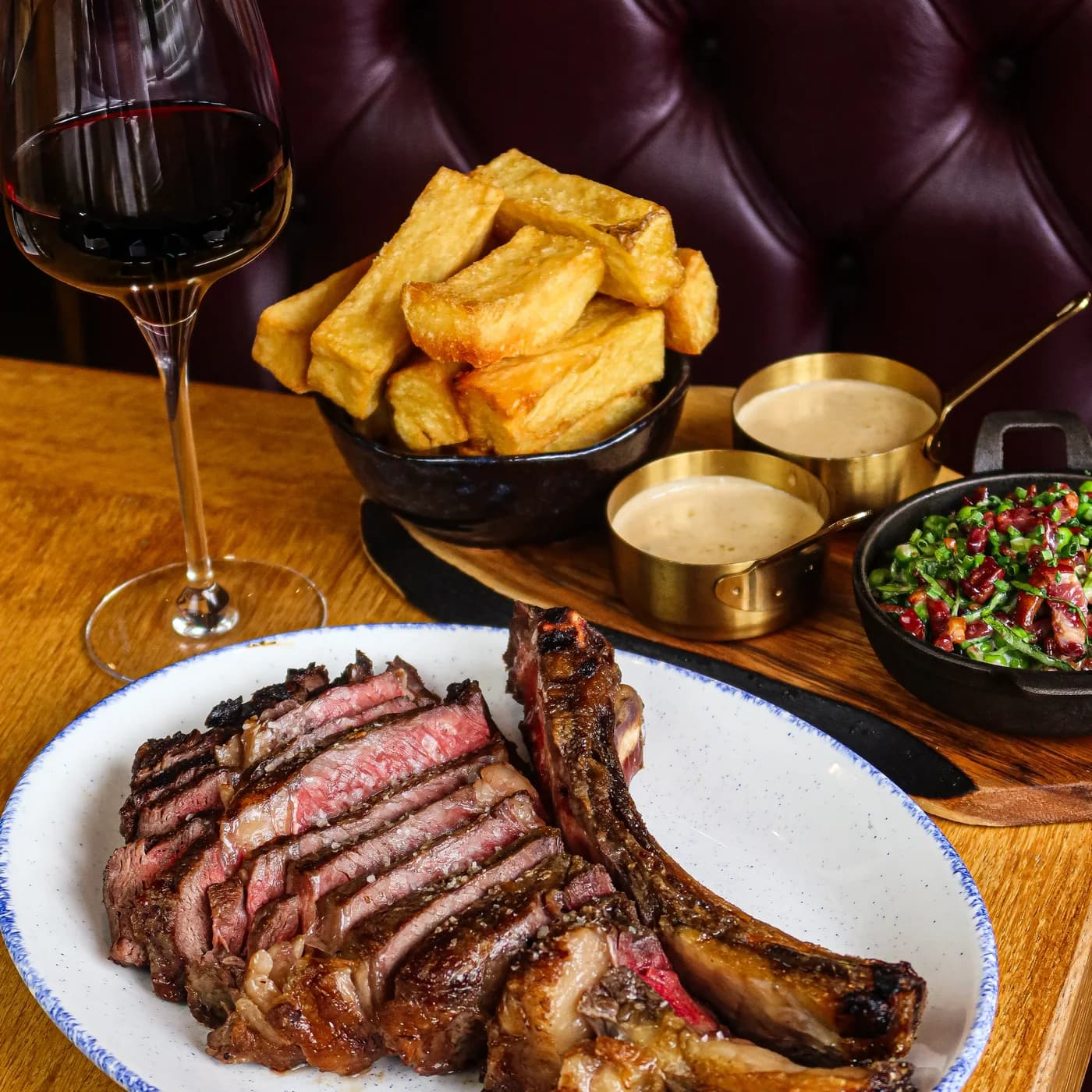 Côte de bœuf sliced on the bone at The Piccadilly Inn, with triple-cooked chips, peppercorn and chimichurri and a glass of red